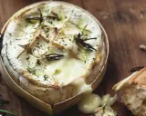 Camembert fondant au barbecue gaz, arrosé d'herbes et servi avec une baguette croustillante. Un délice à partager.