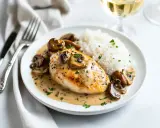 Un délicieux poulet aux morilles à la crème, servi avec du riz blanc et garni de persil frais. Un plat savoureux et réconfortant.