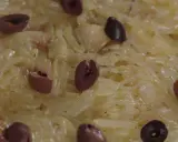 Un délice de confit d'oignon, parsemé d'olives noires, prêt à être dégusté.
