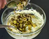 Ajout de câpres et cornichons hachés à une base crémeuse pour préparer une sauce gribiche savoureuse.