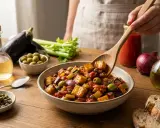 Un plat coloré de caponata, une recette sicilienne savoureuse avec aubergines, olives et tomates.