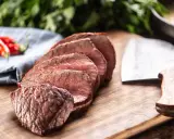 Tranches de rôti de bœuf, poivrons rouges et couteau de boucher. Que faire avec ce reste de viande cuite ?