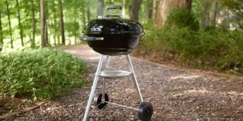Barbecue Weber noir, prêt pour un repas en plein air. L'origine des bons moments.