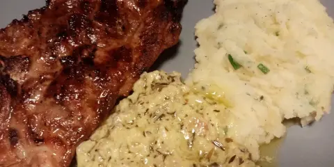 Steak grillé servi avec purée de pommes de terre et une onctueuse sauce à l'estragon pour viande.