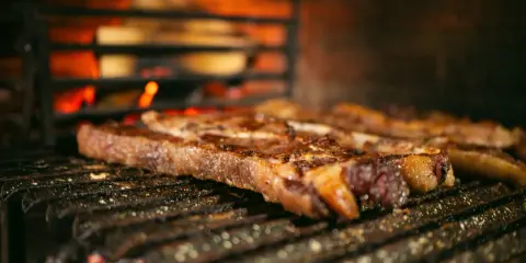 Bifteck grillé sur le feu, prêt à être servi avec une sauce piquante.