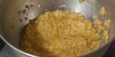 Un bol en métal contient une purée de lentilles corail, prête à être cuisinée.