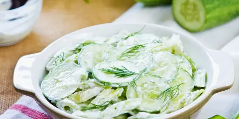 Salade de concombre crémeuse, parfaite pour une recette légère et rafraîchissante. Des rondelles de concombre frais nappées d'une sauce onctueuse et garnies d'aneth.