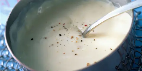 Sauce béchamel sans beurre, onctueuse et parsemée de poivre, prête à être dégustée.