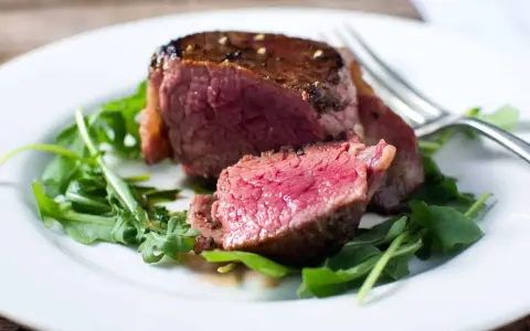 Un délicieux filet mignon, saignant et tendre, servi sur un lit de roquette fraîche.