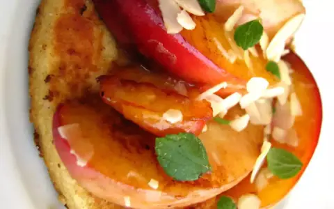 Tranches de fruits grillés sur pain toasté, garnies d'amandes effilées et de menthe.