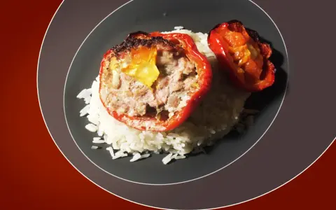 Poivrons rouges farcis à la viande hachée, servis sur un lit de riz blanc. Une recette savoureuse pour savoir quelle viande pour tomates farcies.