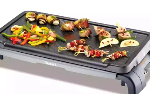 Brochettes de noix de Saint-Jacques et légumes colorés sur une plancha Tefal, prêts à être grillés pour un repas savoureux.