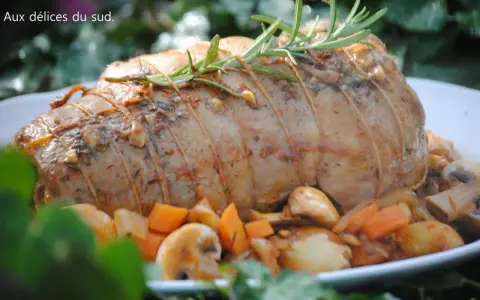 Un rôti d'agneau à la cocotte en fonte, savamment lié et garni de romarin, entouré de légumes rôtis.