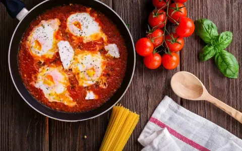 Œufs pochés dans une sauce tomate savoureuse, rappelant la sauce armoricaine, avec des tomates fraîches et du basilic.