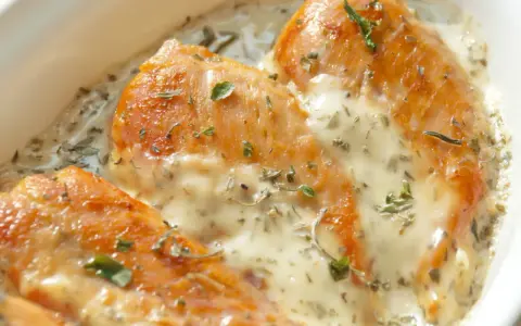 Trois morceaux de poulet au four dorés, nappés d'une sauce crémeuse et garnie d'herbes. Une sauce d'accompagnement pour poulet au four parfaite.