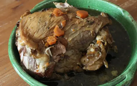 Gigot de 7 heures, un plat mijoté à la perfection, comme dans "Les Carnets de Julie". La viande est tendre et savoureuse, avec des carottes et des herbes.