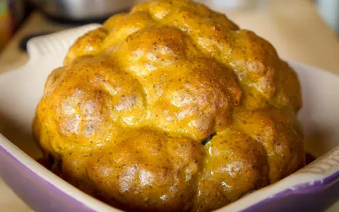 Un chou-fleur entier, doré et appétissant, prêt à être dégusté. Ce chou-fleur barbecue a une belle croûte caramélisée.