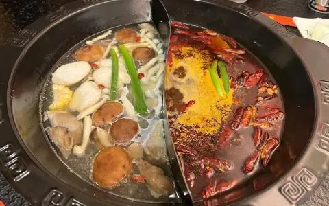 Une fondue chinoise à deux bouillons : un clair avec champignons et légumes, l'autre épicé aux piments.