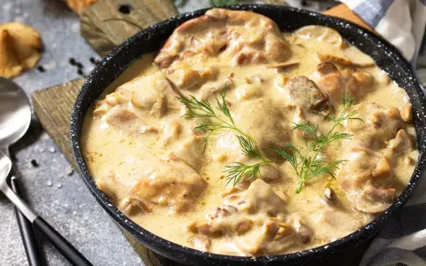 Poulet de Bresse à la crème, servi dans une poêle, garni d'aneth.