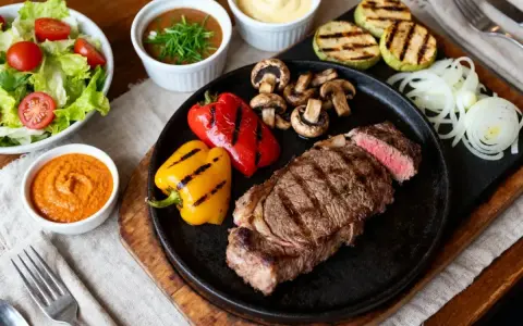 Un steak grillé, poivrons, champignons, courgettes et une sauce pierrade maison savoureuse.