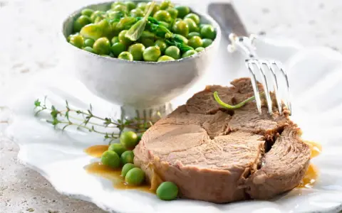 Un tendre morceau d'agneau, prêt à être dégusté, accompagné de petits pois frais. Une idée pour une recette agneau cocotte minute Seb.