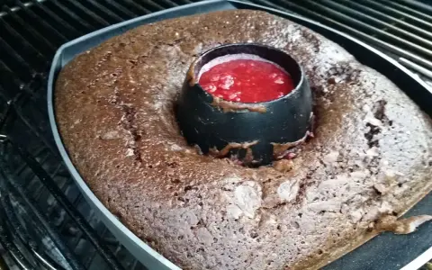 Gâteau au barbecue, un délice chocolaté avec un cœur de coulis de fruits rouges, prêt à être dégusté.
