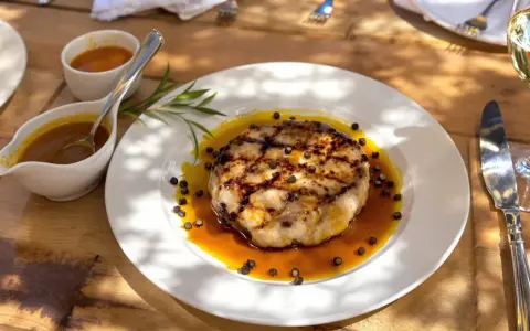 Un plat de viande grillée, nappé d'une sauce savoureuse et parsemé de poivre. Une sauce à viande qui promet un délice.