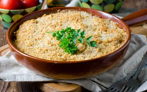 Un délicieux crumble de légumes, doré et croustillant, garni de persil frais. Parfait pour un repas réconfortant.