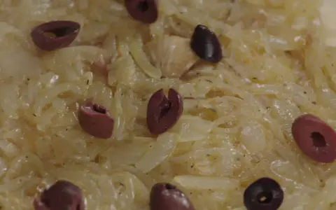 Un délice de confit d'oignon, parsemé d'olives noires, prêt à être dégusté.