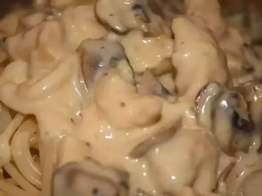 Spaghetti crémeux avec des morceaux de poulet et des champignons, le tout nappé d'une onctueuse sauce béchamel. Un plat réconfortant.