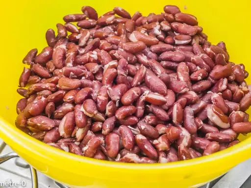 Gros plan sur des haricots rouges dans un bol jaune, prêts pour une délicieuse recette haricot rouge.