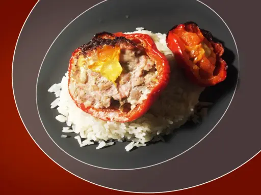 Poivrons rouges farcis à la viande hachée, servis sur un lit de riz blanc. Une recette savoureuse pour savoir quelle viande pour tomates farcies.