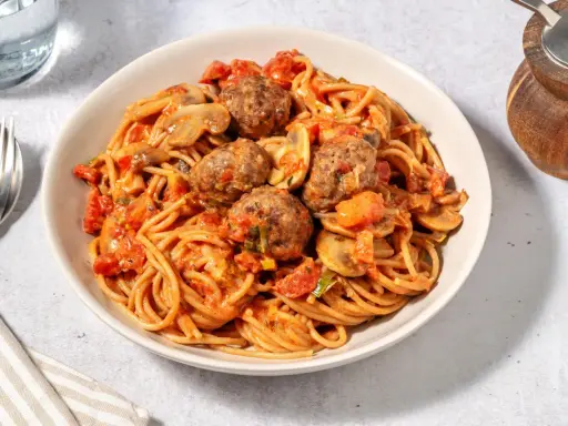 Spaghetti avec boulettes de viande et champignons, nappés d'une sauce tomate savoureuse. Quelle viande avec sauce tomate !