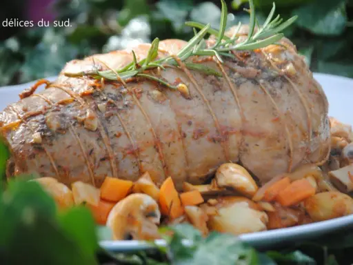 Un rôti d'agneau à la cocotte en fonte, savamment lié et garni de romarin, entouré de légumes rôtis.
