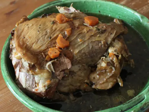 Gigot de 7 heures, un plat mijoté à la perfection, comme dans "Les Carnets de Julie". La viande est tendre et savoureuse, avec des carottes et des herbes.