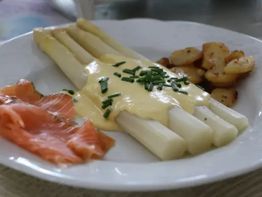 Asperges blanches nappées de sauce hollandaise, accompagnées de saumon fumé et de pommes de terre sautées. Un délice !