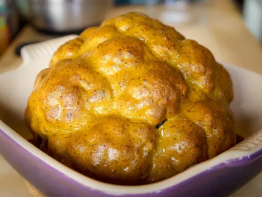Un chou-fleur entier, doré et appétissant, prêt à être dégusté. Ce chou-fleur barbecue a une belle croûte caramélisée.