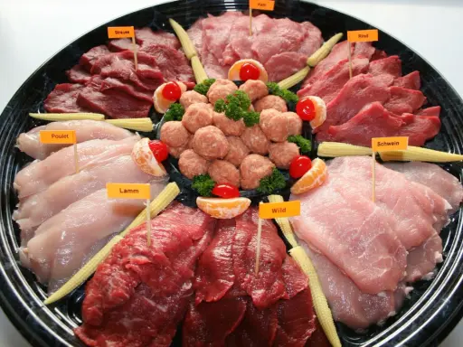 Plateau de viandes variées pour fondue, évoquant la fondue bourguignonne et son origine. On y trouve bœuf, poulet, agneau, porc, veau et gibier.