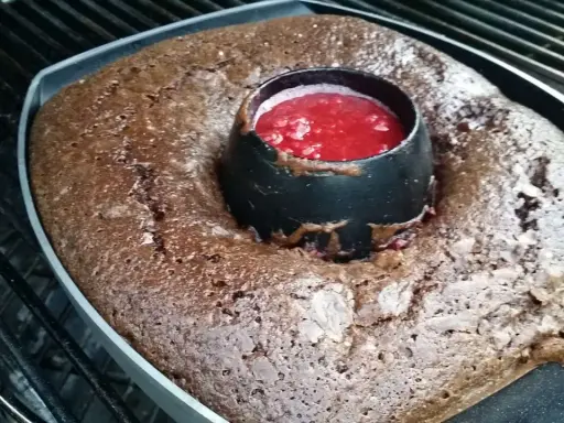 Gâteau au barbecue, un délice chocolaté avec un cœur de coulis de fruits rouges, prêt à être dégusté.