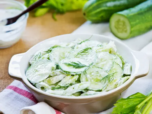 Salade de concombre crémeuse, parfaite pour une recette légère et rafraîchissante. Des rondelles de concombre frais nappées d'une sauce onctueuse et garnies d'aneth.