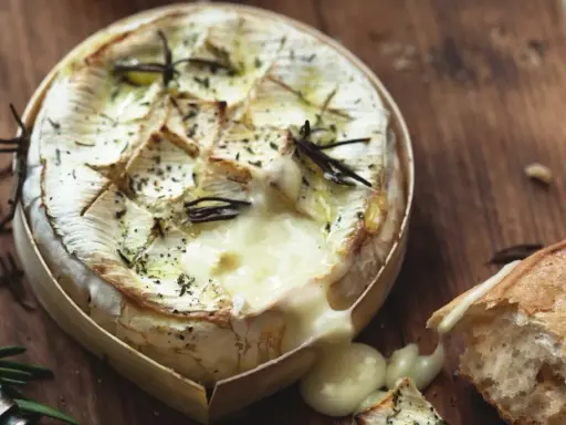Camembert fondant au barbecue gaz, arrosé d'herbes et servi avec une baguette croustillante. Un délice à partager.