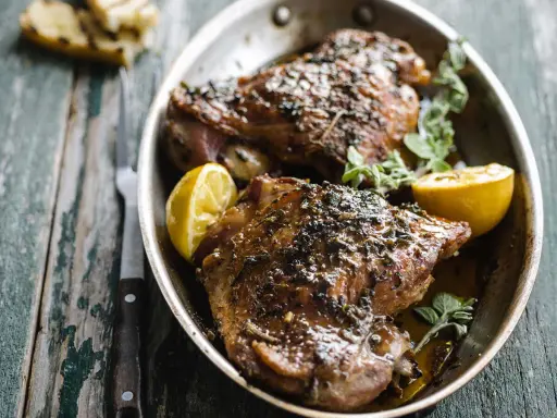 Deux belles cuisses de dinde au four, dorées et savoureuses, garnies de citron et d'herbes fraîches. Un délice !