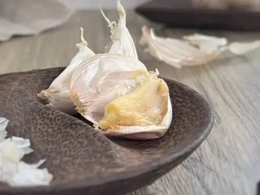 Ail confit au four, doux et doré, prêt à parfumer vos plats.