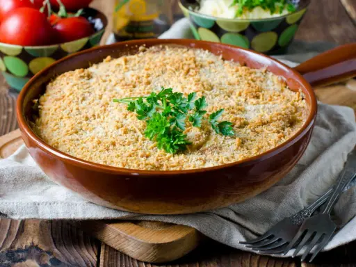 Un délicieux crumble de légumes, doré et croustillant, garni de persil frais. Parfait pour un repas réconfortant.