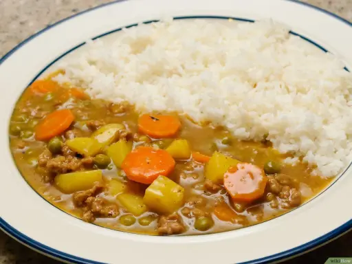 Un plat de riz blanc servi avec un curry japonais savoureux, garni de morceaux de carottes, de pommes de terre et de petits pois.