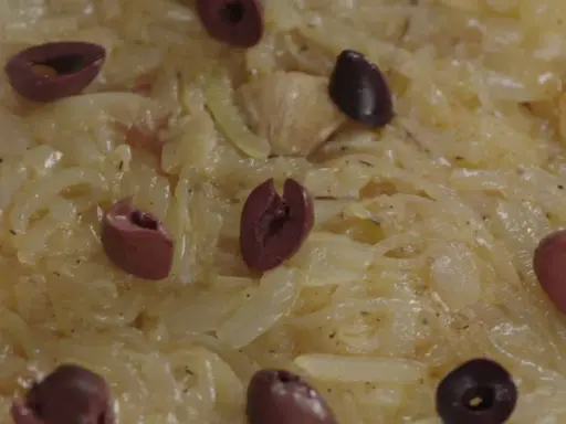 Un délice de confit d'oignon, parsemé d'olives noires, prêt à être dégusté.