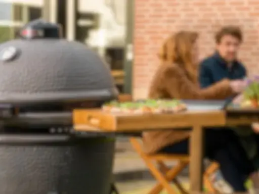 Un couple profite d'un repas en plein air avec une pizza fraîchement préparée, la cuisson kamado promettant une saveur incomparable.