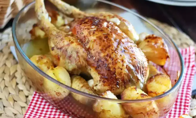 Poulet rôti doré avec pommes de terre dans un plat en verre. Une belle idée pour vos recettes avec poulet.