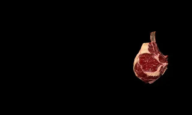 Un morceau de t bone boeuf, avec son os apparent, est présenté sur fond noir. Son emplacement est sur la droite de l'image.
