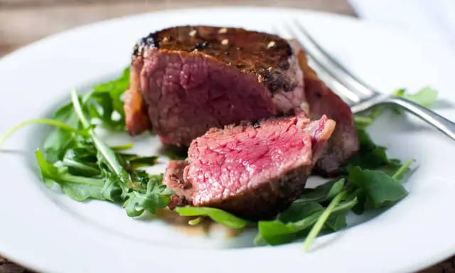 Un délicieux filet mignon, saignant et tendre, servi sur un lit de roquette fraîche.